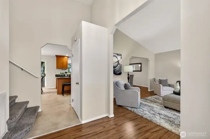 Step into a bright foyer that opens to vaulted living space and easy sight lines toward the kitchen and dining area. This level also includes a convenient powder room, ideal for guests and everyday use.
