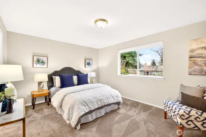 The primary bedroom offers a calm, spacious retreat with plush carpet and a wide window that brings in natural light. The generous layout provides flexibility for your preferred bedroom setup, plus room for a sitting area or workspace to support the way you live day to day.