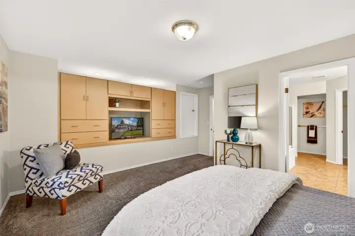 The primary bedroom offers a generous retreat with plenty of room for a king size setup and a sitting area. Built in cabinetry adds excellent storage and a clean, streamlined look, with convenient access to the attached bath.