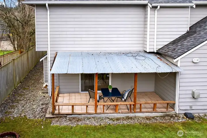 This exterior view highlights the covered patio and the easy access from the home to the backyard. It’s a practical setup for outdoor dining, lounging, or weekend projects, with fencing that adds privacy and definition to the space.