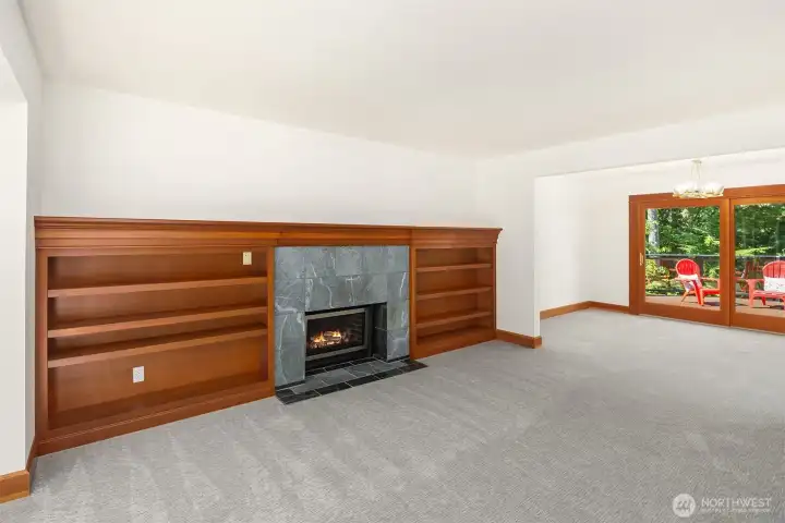 Formal Living Room with beautiful clear Walnut shelving and gas fireplace flows seamlessly to the dining room and the slider leading to the back deck.