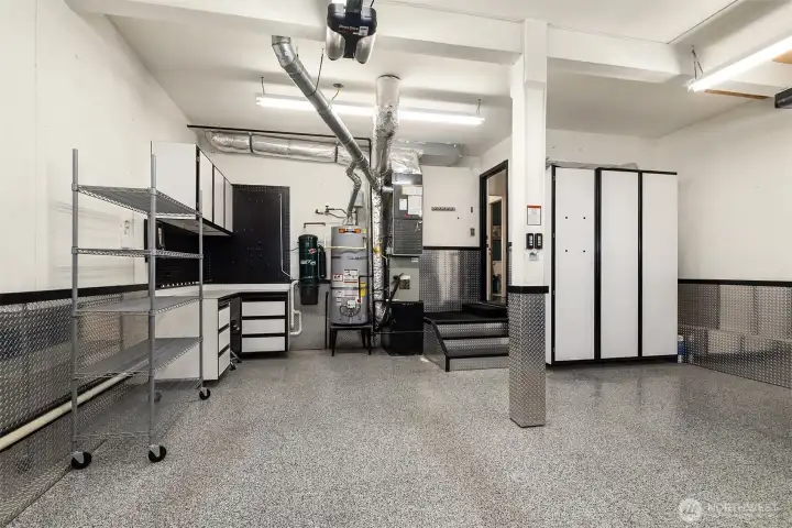 Dream garage! Epoxy flooring, diamond plate walls, work bench and tons of storage in this attached two-car garage