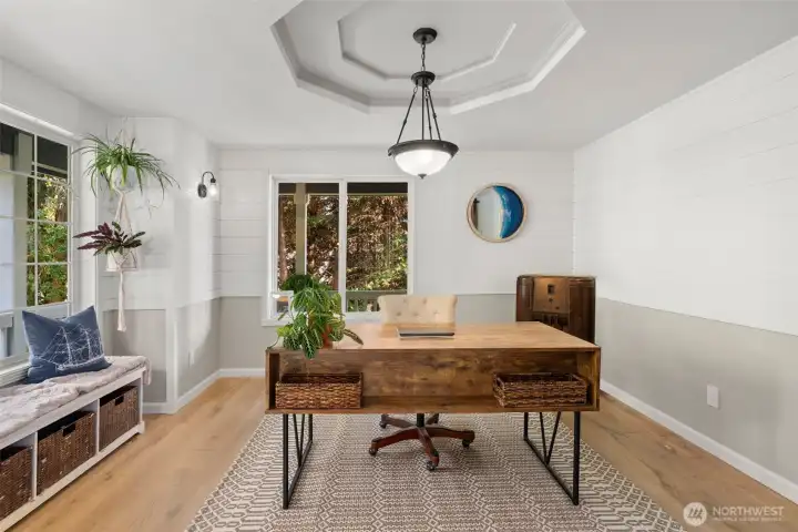 The office on the main floor has large windows and overlooks the chicken coop and green space.