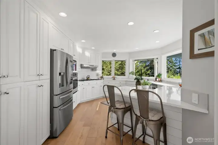 The large kitchen opens up into a stunning view of the sound and back yard. With all upgraded appliances, extra seating and quartz countertops, and tons of storage - this kitchen truly has it all.