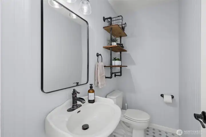 The main floor half bathroom is both functional and continues the modern coastal vibe of the home with beachy wainscoting.
