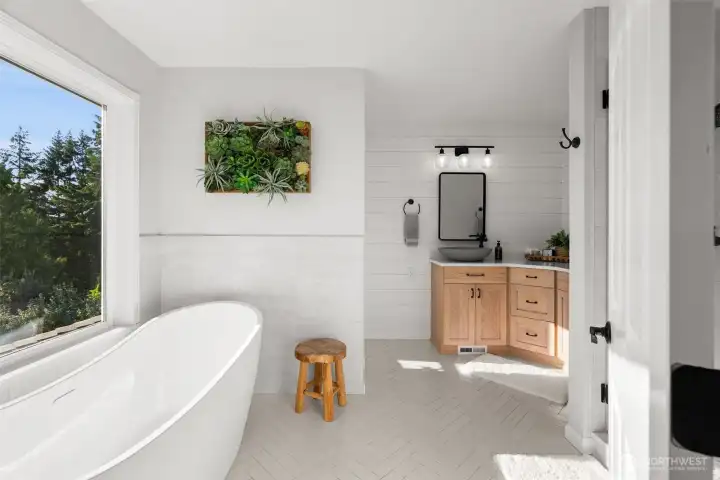 The primary ensuite features a soaking tub with a view, frameless glass shower, duel vanities and water closet.