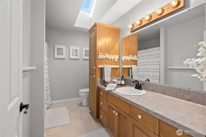 The upstairs full bathroom is light and bright with a large skylight and vaulted ceilings.