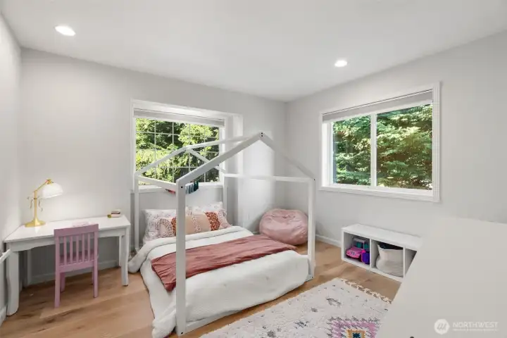 The fourth bedroom upstairs is generously sized and looks to the front yard and green space to the right of the home.