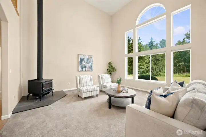 Great room with soaring ceilings, a wall of windows, and cozy wood stove Great room with soaring ceilings, a wall of windows, and cozy wood stove