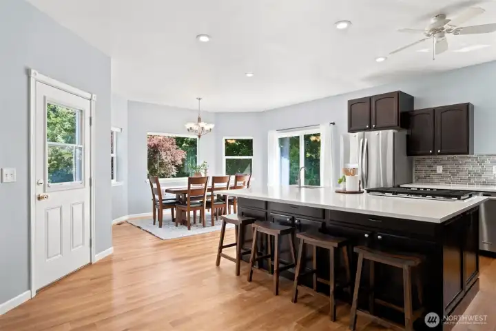 Oversized island, dining area, and backyard access create an inviting gathering space Oversized island, dining area, and backyard access create an inviting gathering space