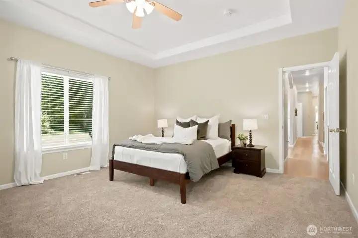Spacious main-level primary suite with tray ceiling and peaceful views Spacious main-level primary suite with tray ceiling and peaceful views