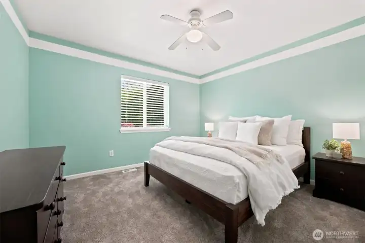 Bright upper-level bedroom featuring a tray ceiling, fresh paint, and generous closet space Bright upper-level bedroom featuring a tray ceiling, fresh paint, and generous closet space