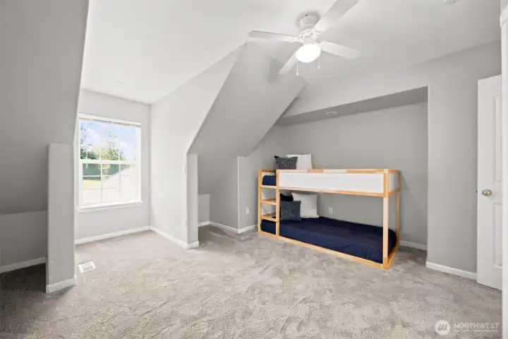 Upper-level bedroom featuring vaulted ceiling lines and abundant storage Upper-level bedroom featuring vaulted ceiling lines and abundant storage