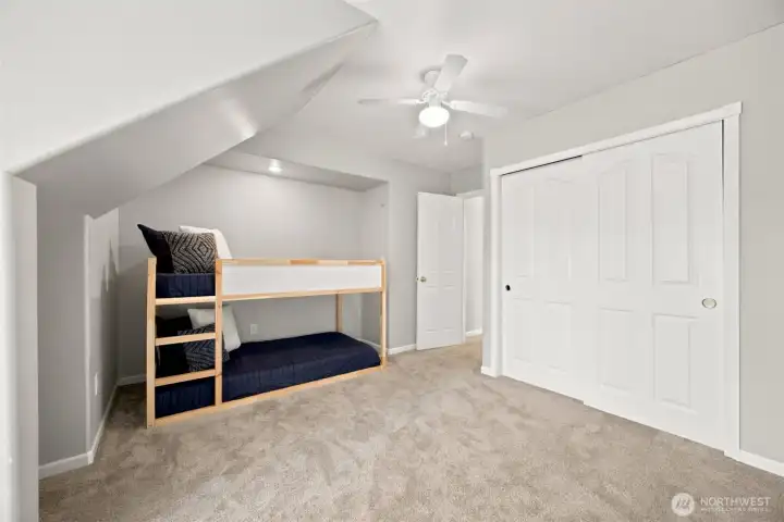 Upper-level bedroom featuring vaulted ceiling lines and abundant storage Upper-level bedroom featuring vaulted ceiling lines and abundant storage