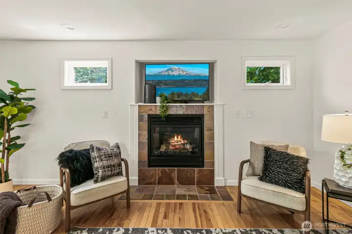 Gas fireplace and tv shelf above make for a focal point between the clerestory windows showing the tree canopy beyond.