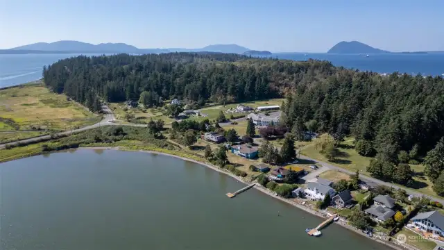 The road leading on to Samish Island. Skagit Land Trust property on the west side of the road. 11586 Scott Rd. is the white building between homes with docks.