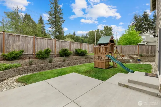 Fully fenced low maintenance backyard with a Large concrete Patio and staircase installed in May 2024