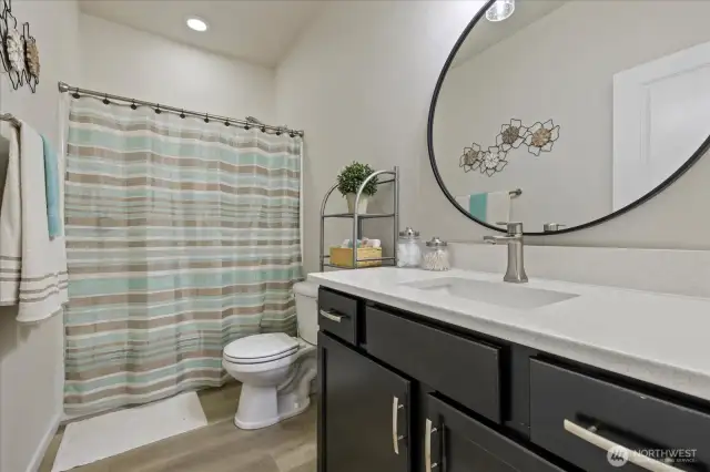 Main Floor Full bath is adjacent to Guest Bedroom and has been updated in 2022 with new LVP flooring, Quartz Countertop, undermount sink and faucet, vanity hardware and lighting