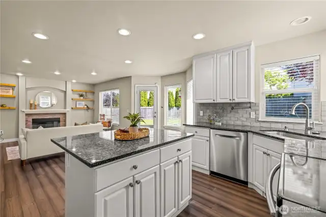 Large open kitchen with updated, stainless appliances, and island flowing to the family room and backyard patio.