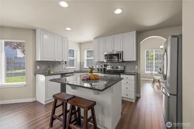 Large open kitchen with updated, stainless appliances, and island flowing to the family room and backyard patio.