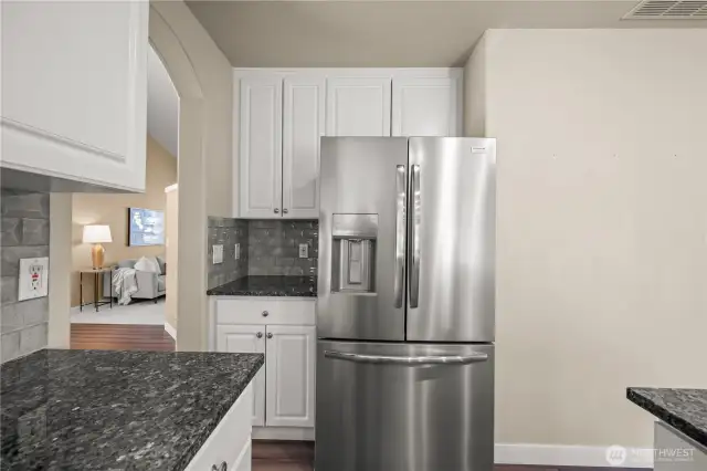 Large open kitchen with updated, stainless appliances, and island flowing to the family room and backyard patio.