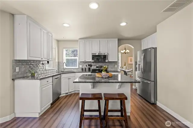Large open kitchen with updated, stainless appliances, and island flowing to the family room and backyard patio.