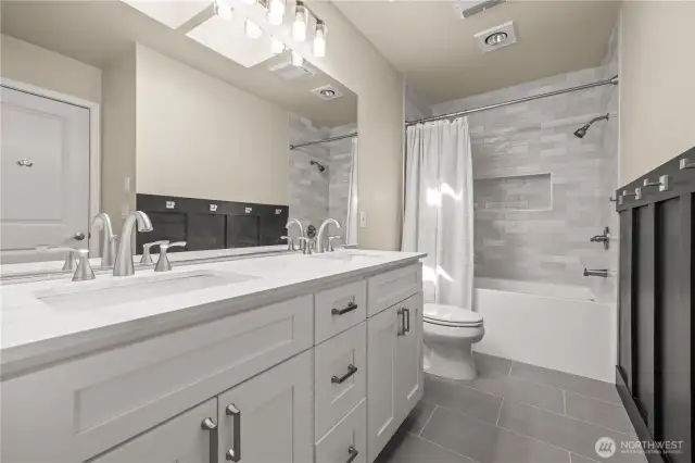 Newly updated bathroom with all new fixtures including quartz counters, new vanity, tile, & bathtub.