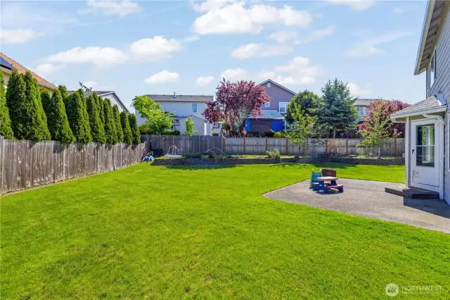 Large, fully fenced backyard with raised garden bed, patio, shed; ready for pets and yard toys.