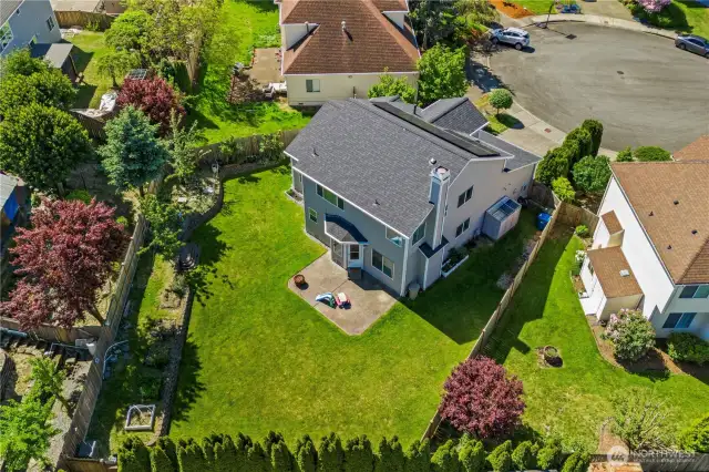 Large, fully fenced backyard with raised garden bed, patio, shed; ready for pets and yard toys.