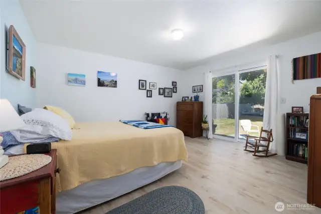The primary suite is spacious and faces the back yard with a slider to access the yard.  LVP (luxury vinyl plank) easy care flooring. Primary has an ensuite private full bath and walk-in closet.