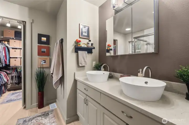 Recently remodeled primary bath, leading to a large walk-in closet.