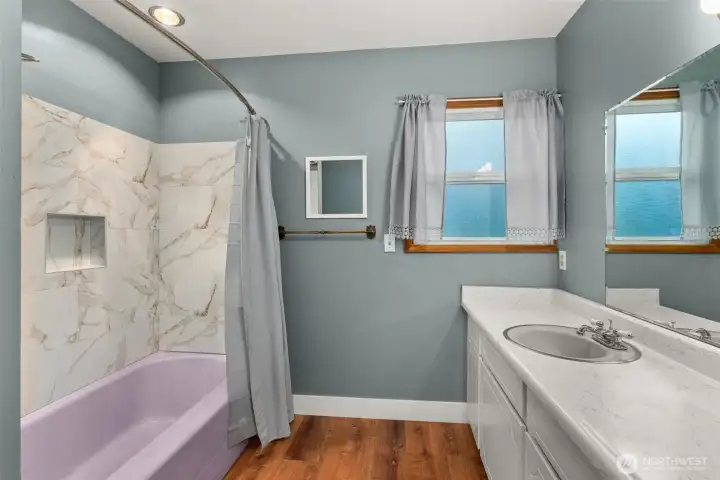 Updated tub surround, flooring and lighting in the main hall bath.
