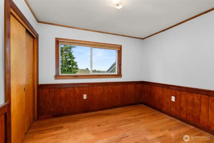 A cozy third bedroom perfect for a guest room, home office, or creative space and it is convenient access to the full hall bath and warm wood accents.