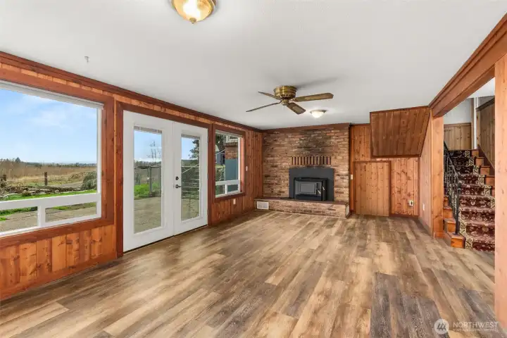 A comfortable lower-level family room offering flexible living space, highlighted by a fireplace with a newer insert. Ideal for movie nights, hobbies, or a cozy retreat on cooler days, the ceiling fan to helps circulate warmth in the winter and keeps the space cool in the summer. There is also additional under the stair storage