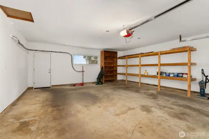 A spacious two-car garage offering secure parking, ample storage, and room for tools or outdoor gear—all with convenient access to the kitchen and pantry for easy unloads on grocery day. It also has access to the back yard.