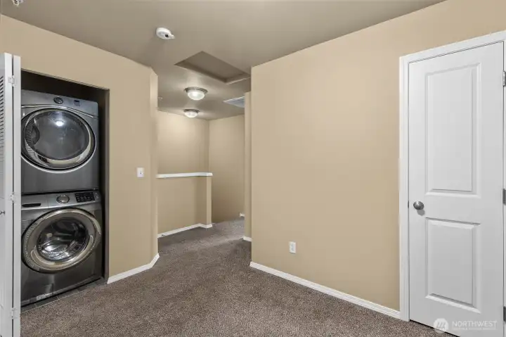 Bonus area between two bedrooms with stackable washer & dryer tucked away in a closet.