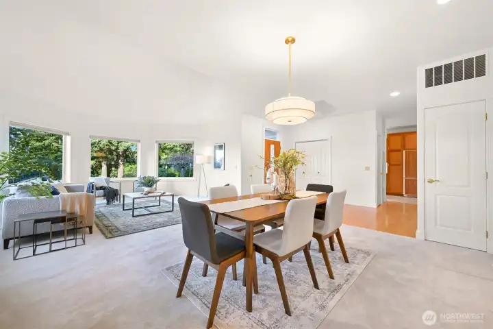 Entry opens to living and dining rooms, high ceilings, framed views.