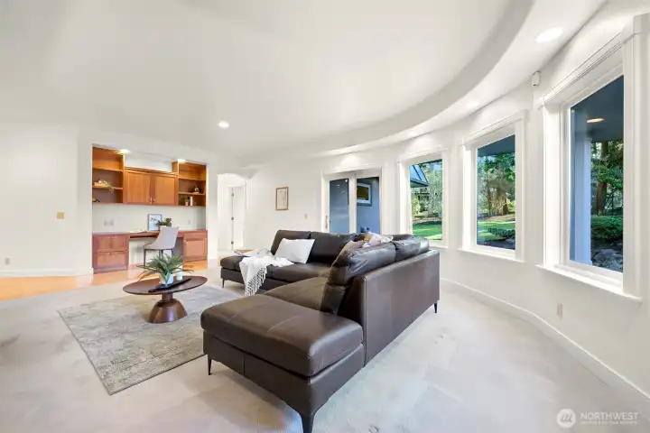 Family room features walls of windows overlooking private backyard.