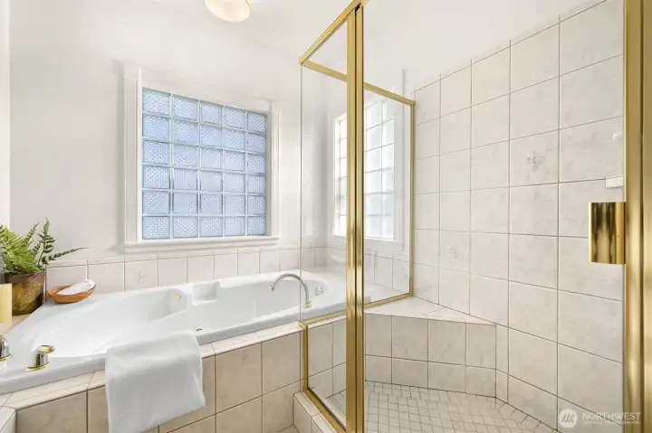 Primary bath features cherry linen closet, double vanity, jetted tub, tiled shower.