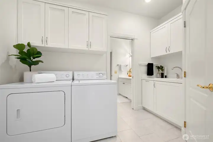 Laundry room with sink, garage access, mudroom functionality, and storage closet.
