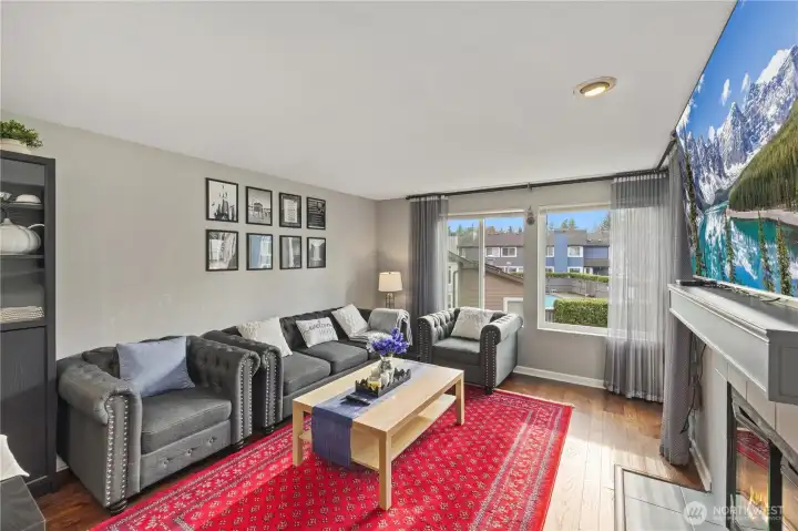 Inviting and enjoyable living room with large windows, sliding door to balcony and a wood fireplace.