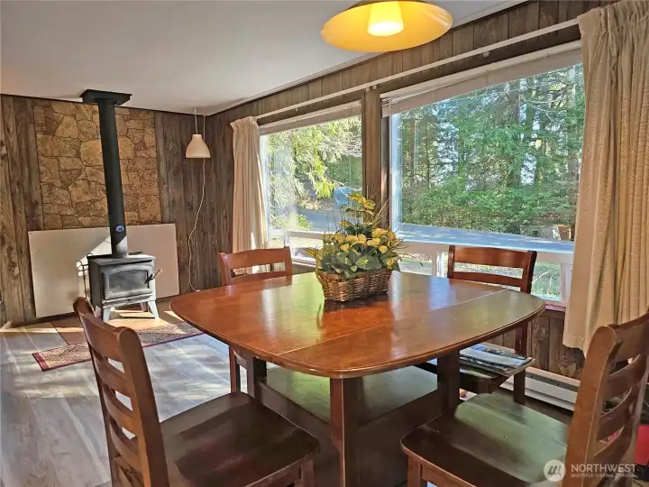 The living room features these huge picture windows and a wood stove for cozy nights in.