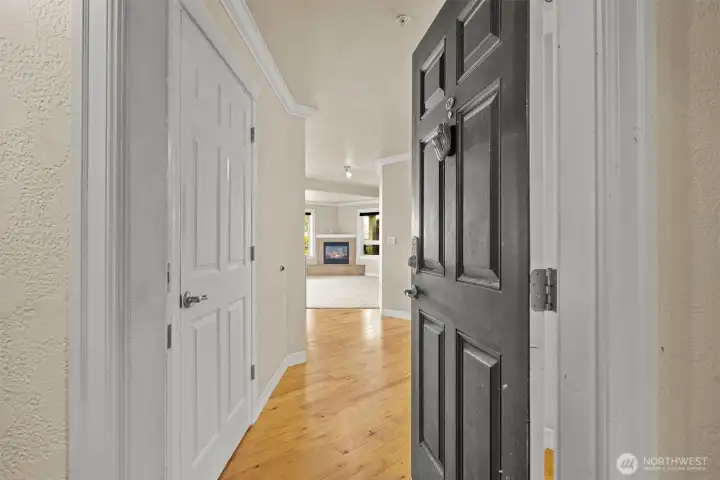 Entry opens to wide hall and main living space open to kitchen, dining and living room with wall of windows.