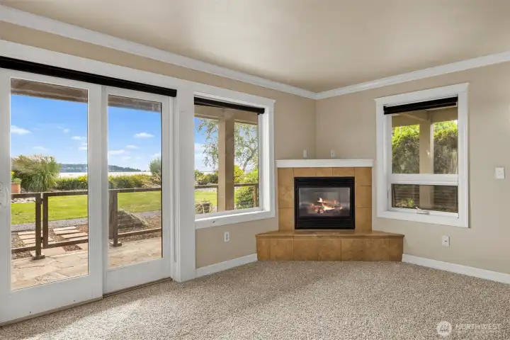 Living room with cozy gas fireplace, door to outdoor living and new carpet.