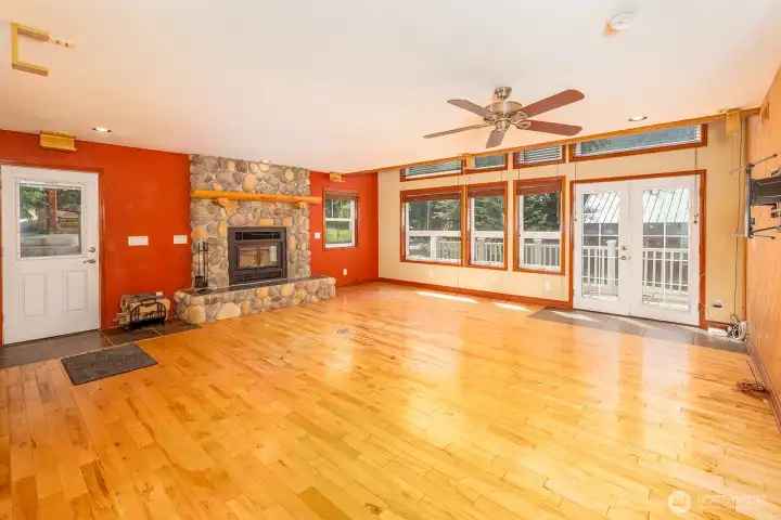 Living  room with stone fireplace and french doors that open to the deck.
