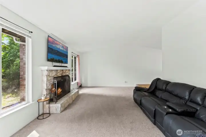 Living room features vaulted ceilings and natural light