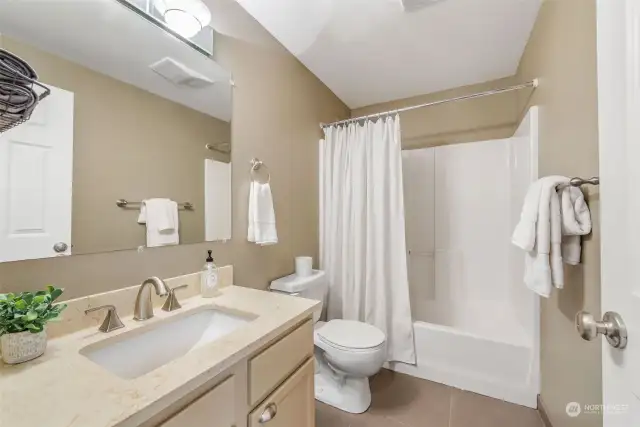 This updated powder room features new stone and a tub/shower combo too!