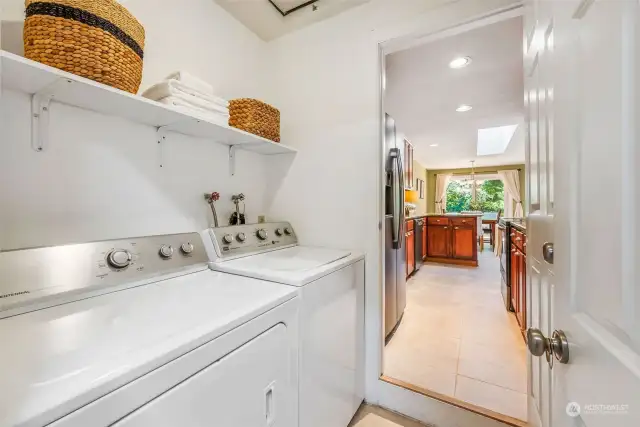 Welcome to the laundry room, which features some shelves, new tile and a new water heater!