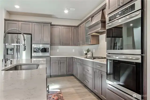 Get a closer look at the elegant details in this chef’s kitchen—premium stainless steel appliances, gas range, upgraded range hood, sleek cabinet pulls, and recessed lighting that enhances both style and functionality. Every element was designed to elevate your cooking experience!