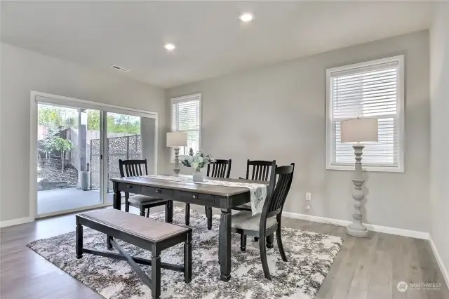 The dining room, conveniently located just off the kitchen, showcases beautiful hardwood laminate flooring that flows effortlessly through the main living areas. Sliding glass doors lead to a covered outdoor patio, transforming this space into an entertainer's dream—perfect for blending indoor elegance with outdoor relaxation!